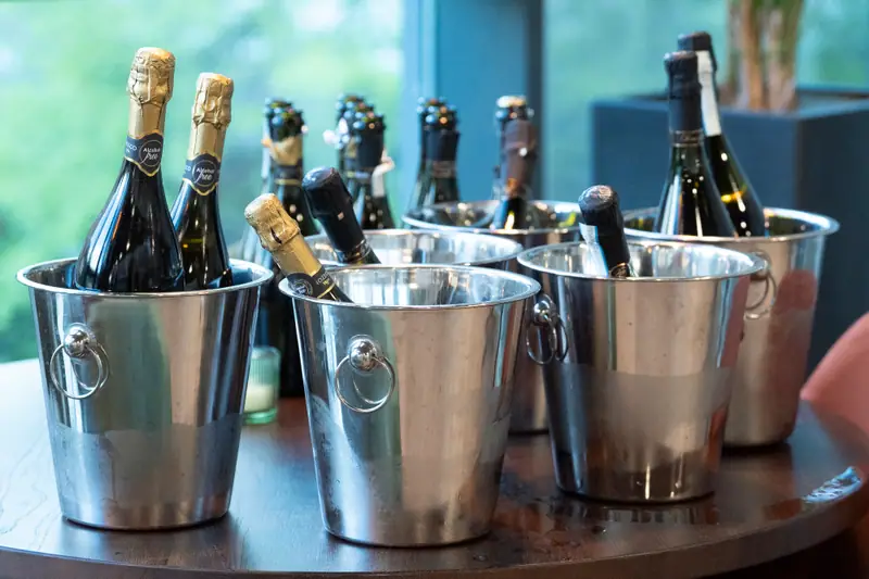Bottles of champagne on ice in silver buckets at the reception.