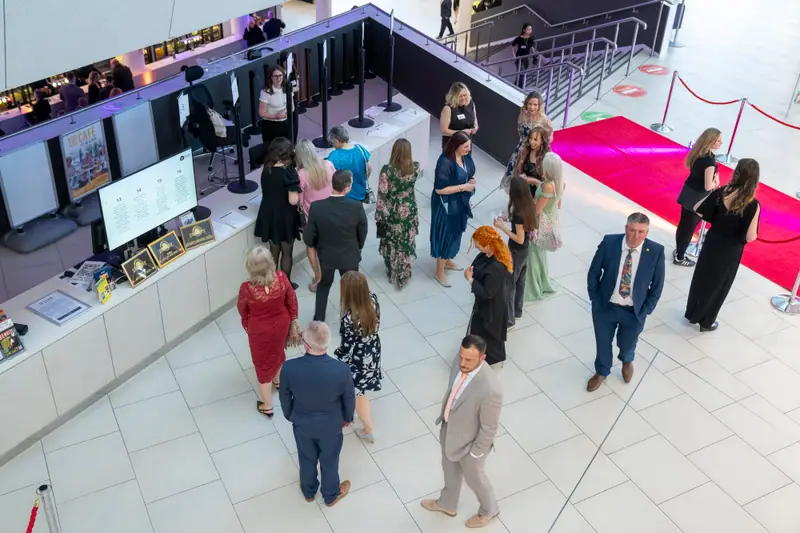 The arrivals hall seen from above, with guests spread along the red carpet.