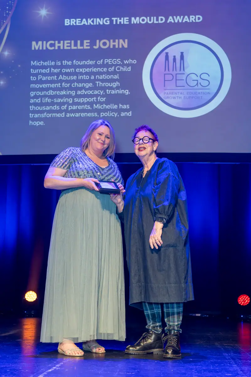 A winner receiving her award on stage as the category slide is shown.