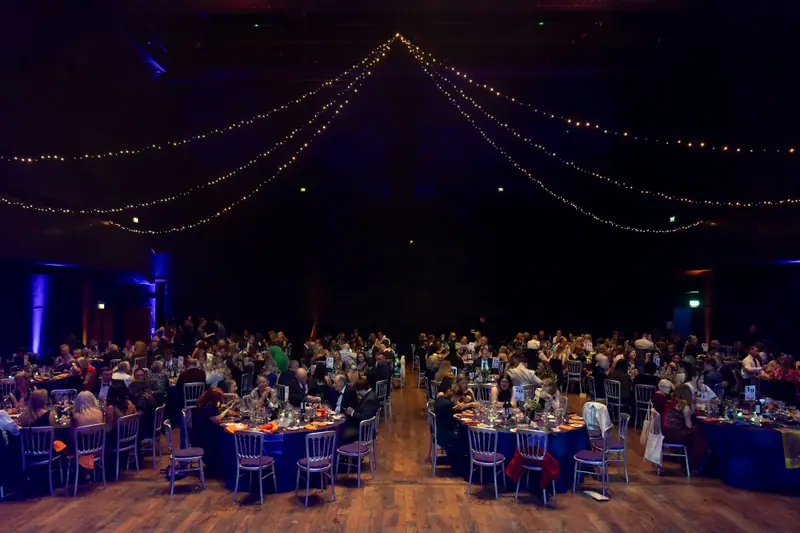 The room at full capacity, seen down the central aisle.
