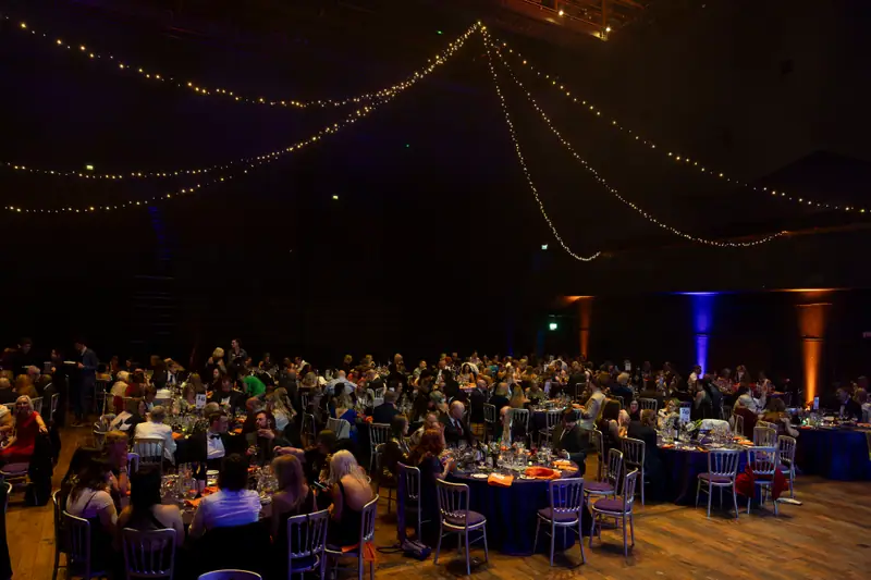 Tables and guests filling the ballroom under strings of lights.