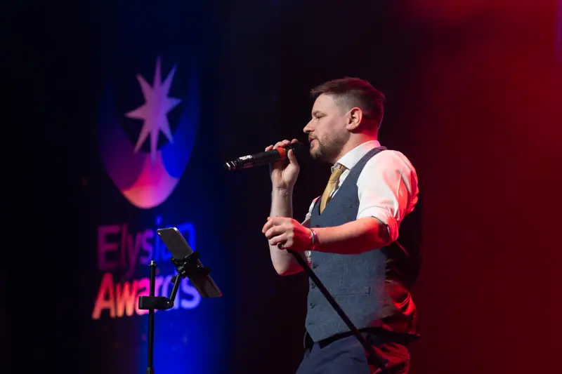 A singer performing on stage under red light after the presentations.