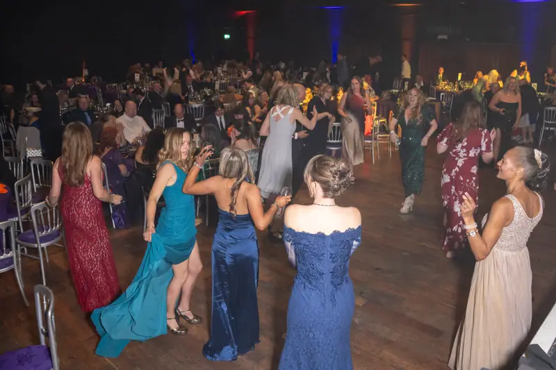 Guests in evening dress dancing in a circle.