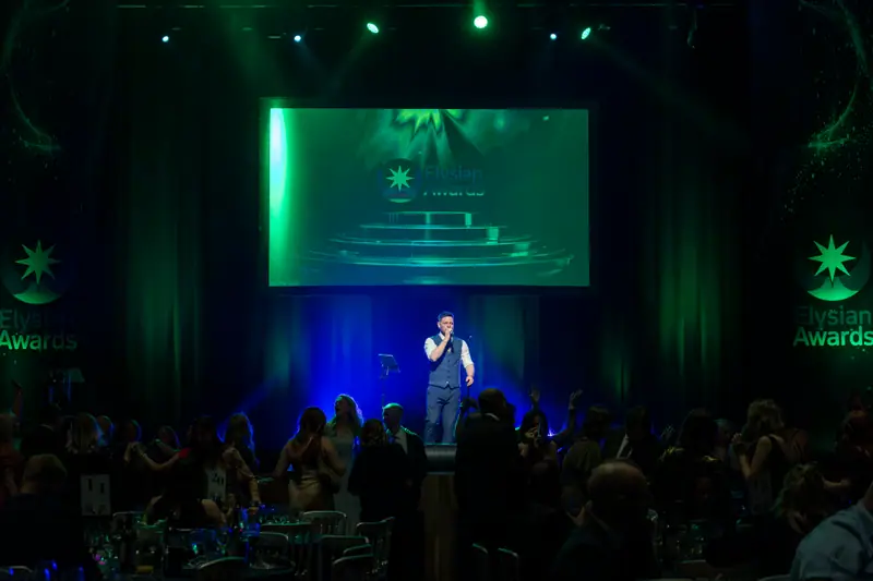 The stage lit green as the singer performs to the room.